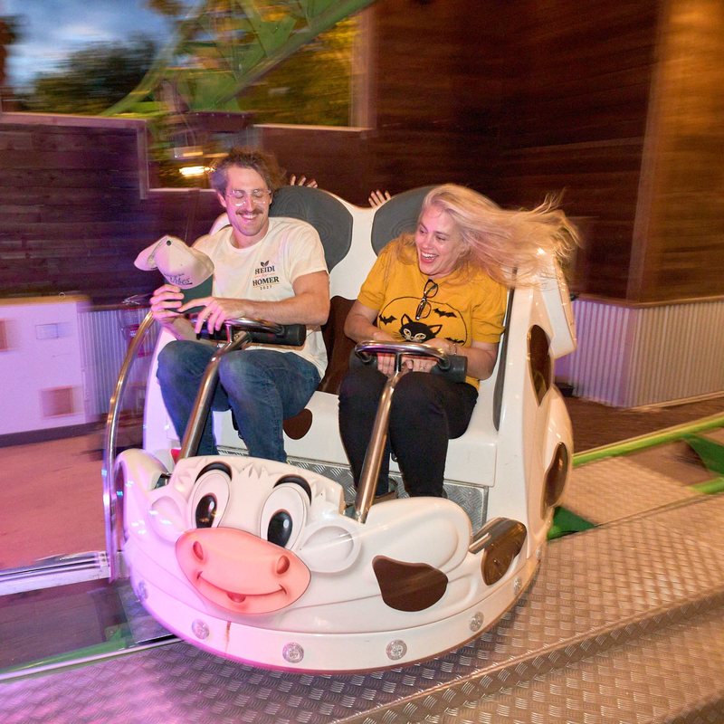 Heidi laughing, hair flying, on the Cow Coaster at Bengtson’s, beside a supporter in a Heidi for Homer shirt.